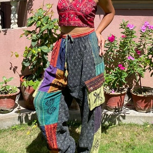 Może przedstawiać: Wielokolorowe spodnie patchworkowe z geometrycznym wzorem i sznurkiem w pasie. Spodnie są wykonane z miękkiej, wygodnej tkaniny i mają luźny krój.