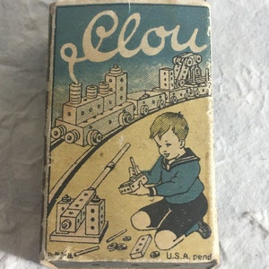 May include: A vintage box of Clou construction toys. The box features a colorful illustration of a child playing with the toys, along with a train made of the blocks. The box is labeled "Clou" and "U.S.A. pend."