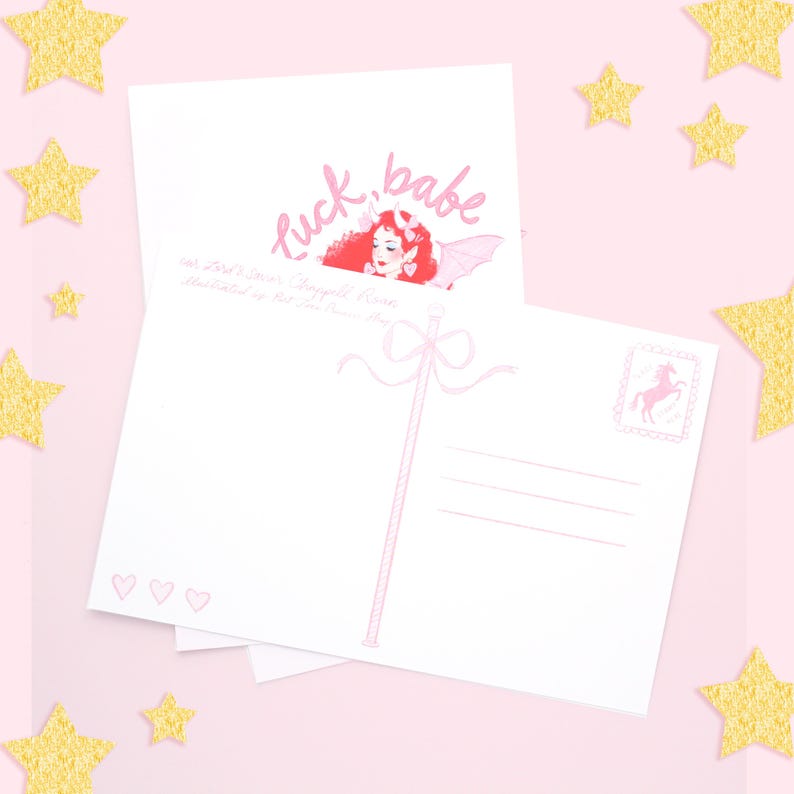May include: A pink and white postcard with the text "luck, babe" and a pink fairy illustration. The back of the postcard has a space for writing a message and a pink unicorn stamp.