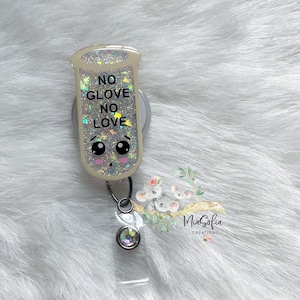 May include: A white glitter badge reel with a clear plastic badge holder. The reel features a cartoon test tube with the text "NO GLOVE NO LOVE" and a cute face. The badge holder has a clear crystal.
