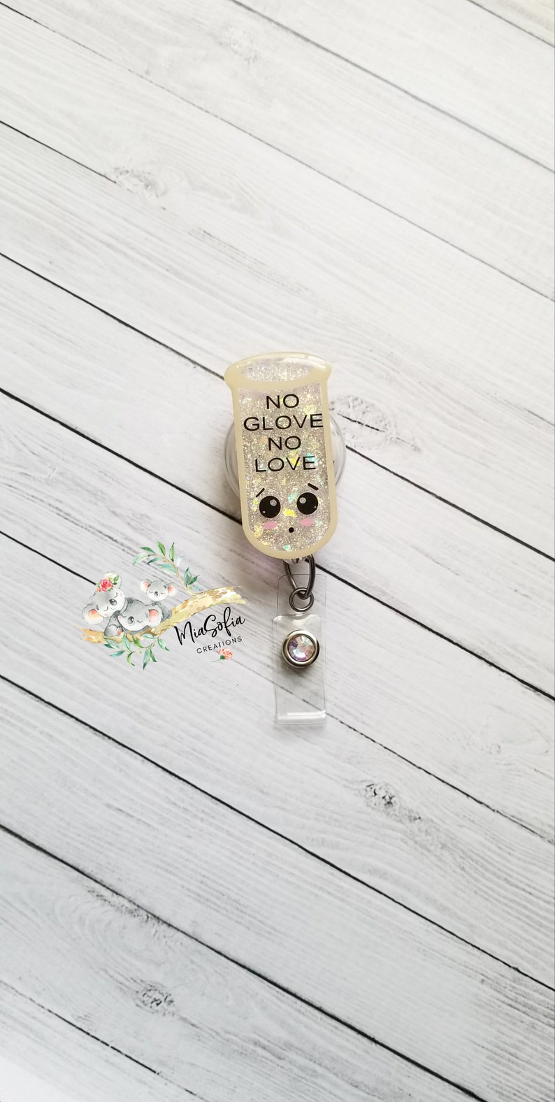 May include: A white glitter badge holder with a cartoon face and the text "NO GLOVE NO LOVE".