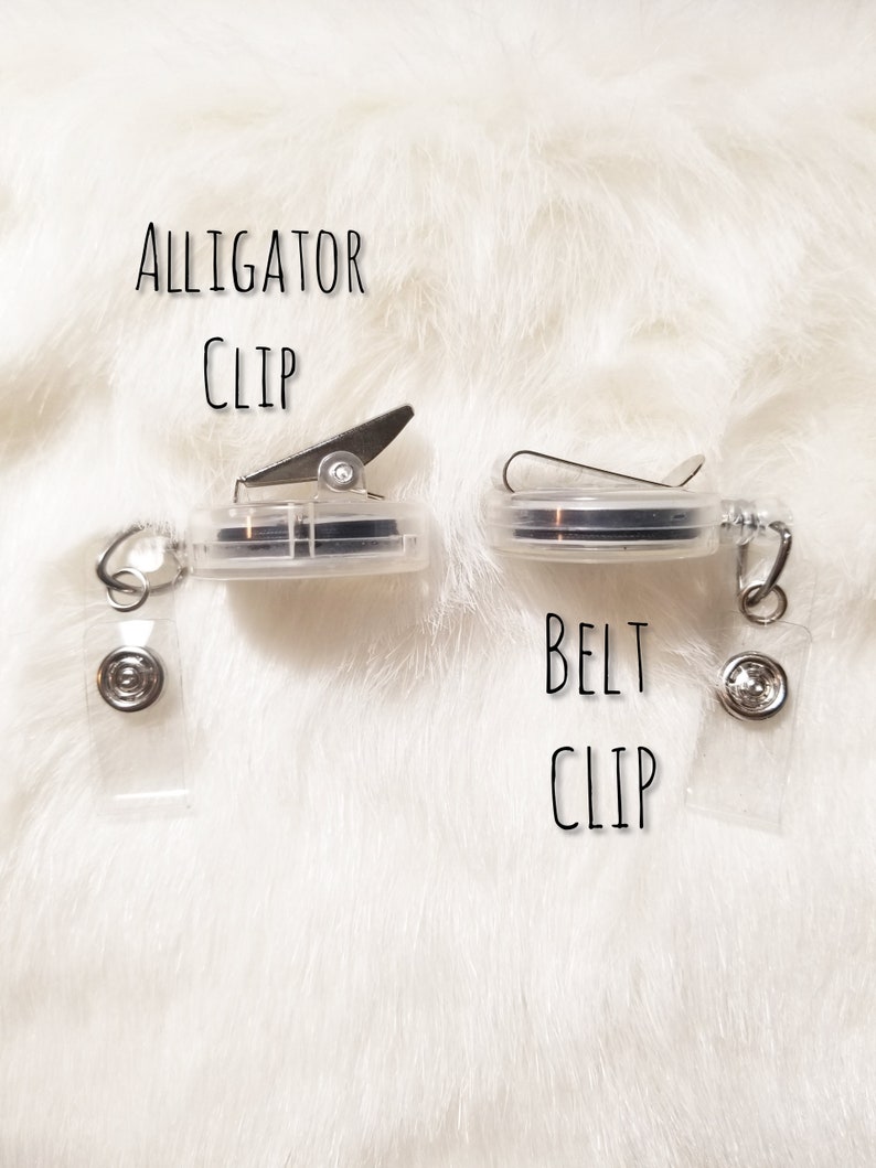May include: Two clear plastic badge holders with metal clips. The holder on the left has an alligator clip and the holder on the right has a belt clip. Both holders have a clear plastic strap.