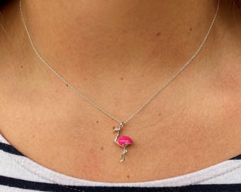 May include: A silver chain necklace featuring a small pendant shaped like a flamingo. The flamingo pendant is finished with a bright pink enamel coating on its body, while the neck, head, and legs are rendered in polished silver metal.