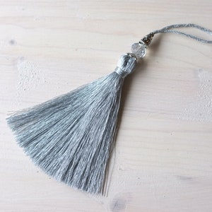 Key tassel shiny silver, gray color, large tassel. Decor for furniture, door or room keys, luxury home decor and cozy details