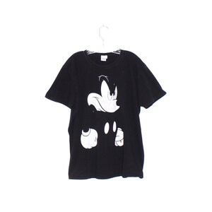 May include: Black t-shirt with a white graphic of Mickey Mouse's face and hand.