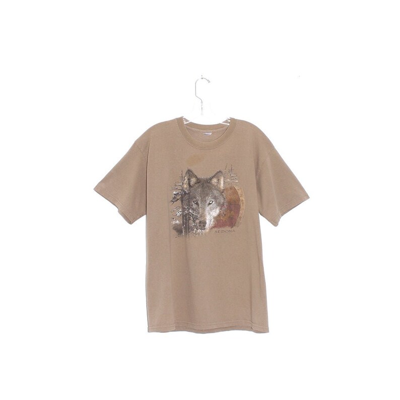 May include: A brown t-shirt with a wolf graphic and the word "Sedona" printed on the front.