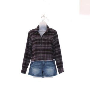 May include: A dark gray and black plaid long-sleeve shirt with a frayed hem, paired with denim shorts. The shorts are a light blue wash. The outfit is displayed on a white mannequin and hanger against a white background.