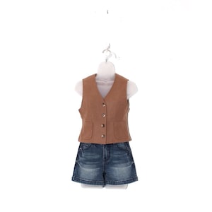 May include: A brown vest with four buttons and two pockets, paired with denim shorts. The vest is displayed on a white mannequin, showcasing a casual outfit. The shorts are a dark wash denim.