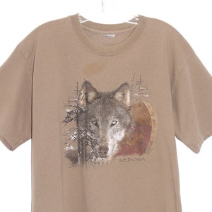 May include: A brown t-shirt with a wolf graphic and the text "SEDONA" printed on the front.