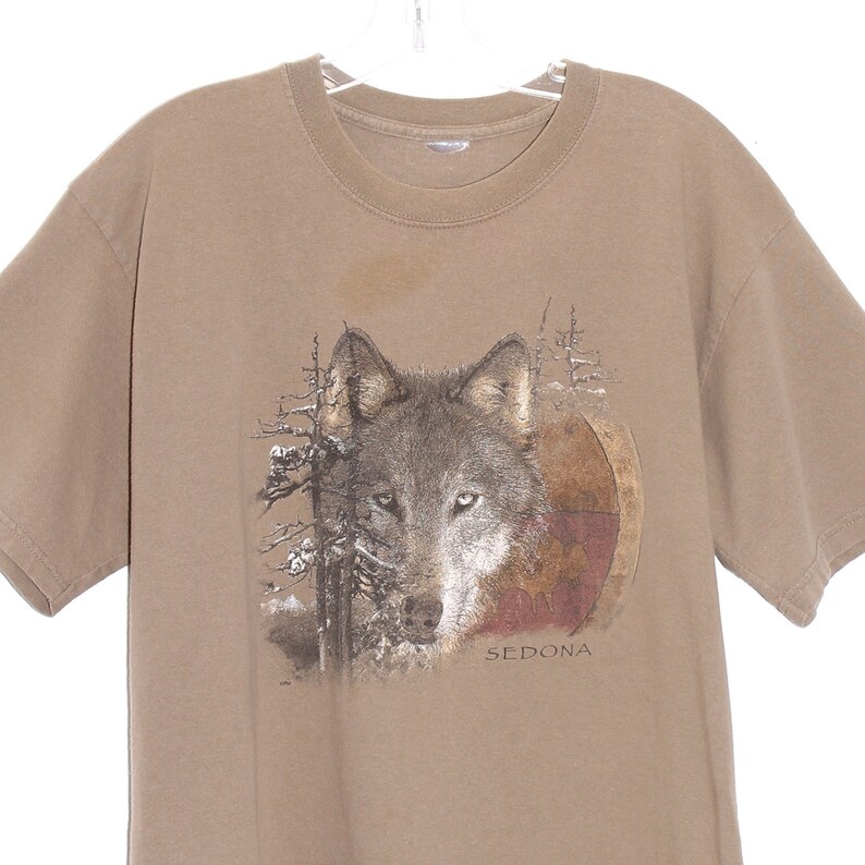 May include: A brown t-shirt with a wolf graphic and the text "SEDONA" printed on the front.