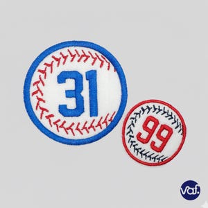 May include: Two baseball-themed patches. One large patch features the number 31 in blue, surrounded by red stitching and a blue border. A smaller patch displays the number 99 in red with black stitching.
