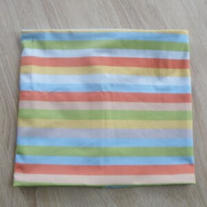 May include: A striped fabric with alternating bands of light blue, peach, light green, and yellow.