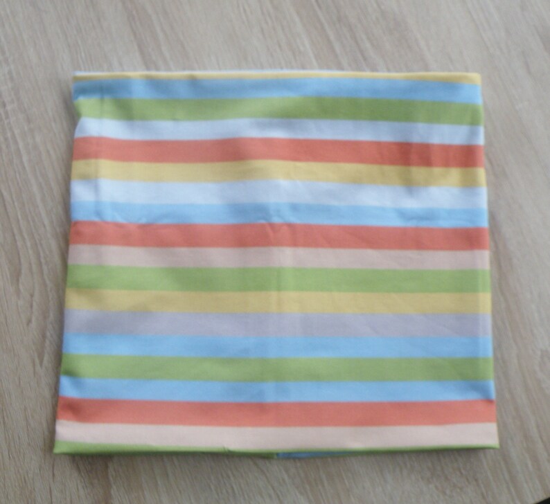 May include: A striped fabric with alternating bands of light blue, peach, light green, and yellow.