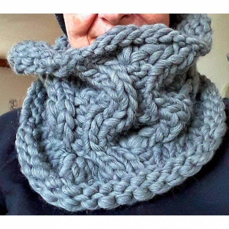 Puede incluir: Una bufanda de cuello de tortuga de punto gris con un patr&oacute;n de punto de cable.