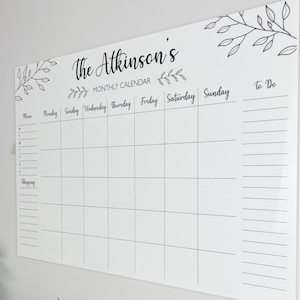 Shows a side view of our large personalised monthly planner mounted on the wall. There is a list for shopping, menu for the week on the left, to do list on the right and squares to add the days of the month in. Made by The Bespoke Workshop.