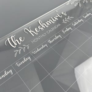 Monthly Planner in clear acrylic with white cursive font. Made by The Bespoke Workshop.