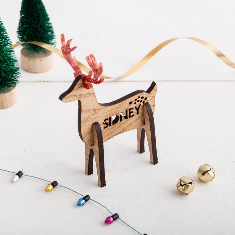 Wooden freestanding reindeer shaped Christmas place setting, personalised with your guests name and finished with glitter antlers.