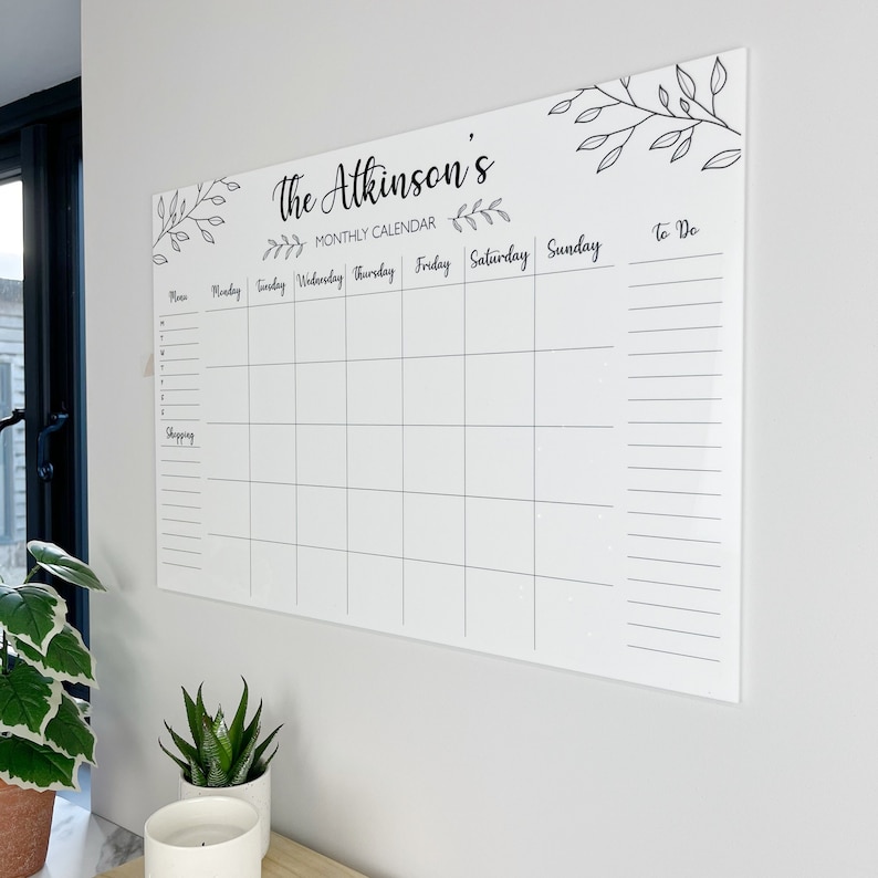 Shows a side view of our large personalised monthly planner mounted on the wall. There is a list for shopping, menu for the week on the left, to do list on the right and squares to add the days of the month in. Made by The Bespoke Workshop.