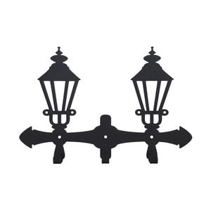 Può includere: Decorazione murale in metallo nero con due lanterne stilizzate collegate da una barra orizzontale con estremità a forma di freccia. Le lanterne hanno un design classico con una parte superiore a punta e barre verticali.