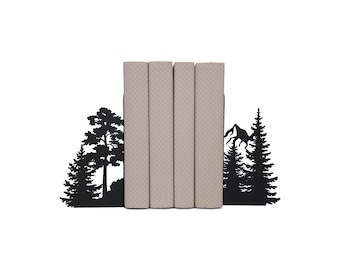 May include: A set of four books with beige covers, held between black metal bookends. The bookends feature a silhouette design of trees and mountains, creating a nature-themed aesthetic. The books are arranged on a white background.