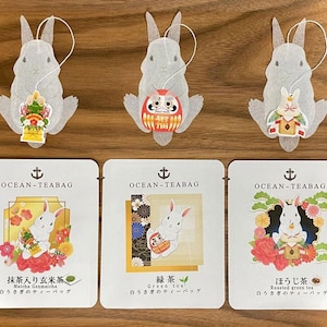 May include: Four tea bags featuring a white rabbit design. Each tea bag is packaged in a clear plastic pouch with a colorful illustration of the rabbit and a description of the tea flavor. The tea flavors are Matcha Genmaicha, Green Tea, Roasted Green Tea, and Hojicha.
