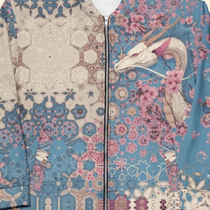 Puede incluir: Chaqueta bomber con cremallera completa con un diseño de dragón y flores de cerezo. La chaqueta presenta un patrón geométrico azul claro y beige en el lado izquierdo y un dragón con flores rosas en el lado derecho.
