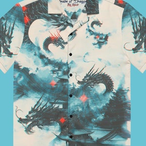 May include: A white short-sleeved button-up shirt with a blue and black dragon print. The shirt has a collar and a button-up front. The text "realm of Dragons by Recir" is printed on the shirt.