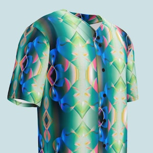 May include: A short-sleeved button-down shirt with a vibrant, abstract pattern. The design features a mix of blue, green, pink, and yellow geometric shapes. The shirt has a V-neck and black buttons.