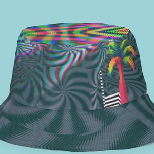 May include: A bucket hat with a psychedelic design. The hat features a swirling pattern in shades of gray and teal, with a colorful palm tree graphic and a vibrant, multicolored top section. The hat is set against a light blue background.