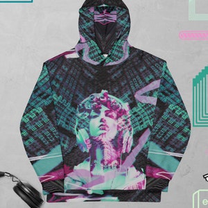 May include: A black hoodie with a colorful graphic print of a woman's face with a digital background. The graphic features a mix of green, blue, pink, and purple colors.