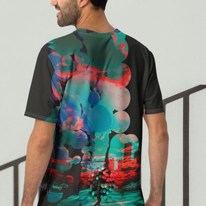 May include: A black t-shirt with a colorful abstract design featuring circles, clouds, and a cityscape. The design is on the back of the shirt.