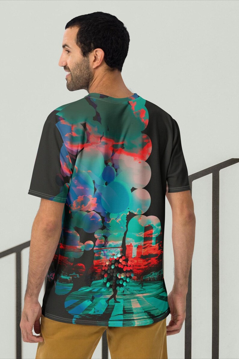May include: A black t-shirt with a colorful abstract design featuring circles, clouds, and a cityscape. The design is on the back of the shirt.