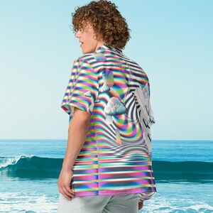 Puede incluir: Una camisa de botones colorida con un patr&oacute;n psicod&eacute;lico que presenta nubes y un dise&ntilde;o de remolino de arco&iacute;ris. La camisa tiene mangas cortas y un ajuste holgado.