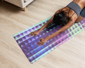 Puede incluir: Una esterilla de yoga rectangular con un patrón geométrico en tonos morados, azules y verdes. El diseño presenta formas y líneas repetitivas. La esterilla parece estar hecha de un material flexible.