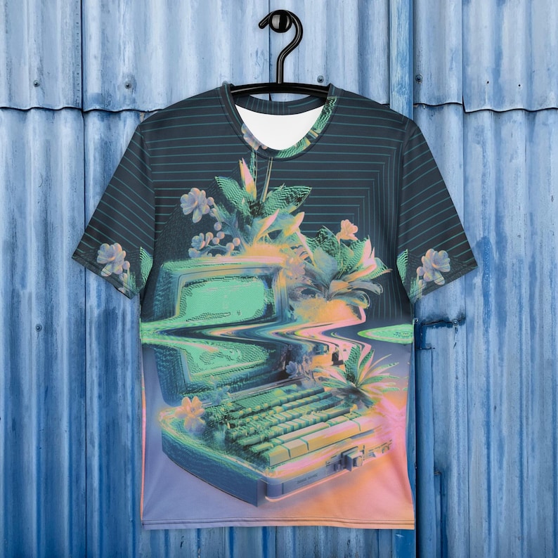 Puede incluir: Una camiseta negra con una computadora retro y flores impresas en ella. La computadora es verde y azul con un teclado y una pantalla. Las flores son rosas, blancas y verdes. El fondo es un patr&oacute;n de rayas azul oscuro y negro.