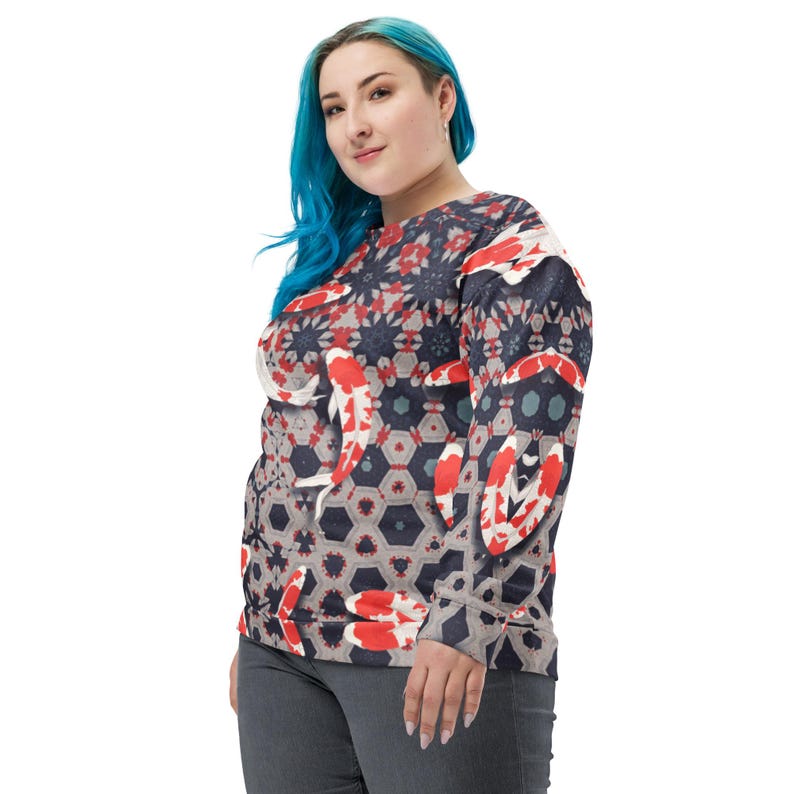 May include: A long-sleeved sweatshirt featuring a koi fish pattern. The design incorporates red, white, and black koi fish against a geometric background of gray, navy, and red shapes. The sweatshirt has a crew neck and a relaxed fit.