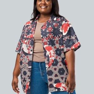 May include: Short-sleeved shirt featuring a koi fish and geometric design in red, white, and navy blue. The shirt is worn with a neutral-toned undershirt and blue jeans. The shirt has a relaxed fit.