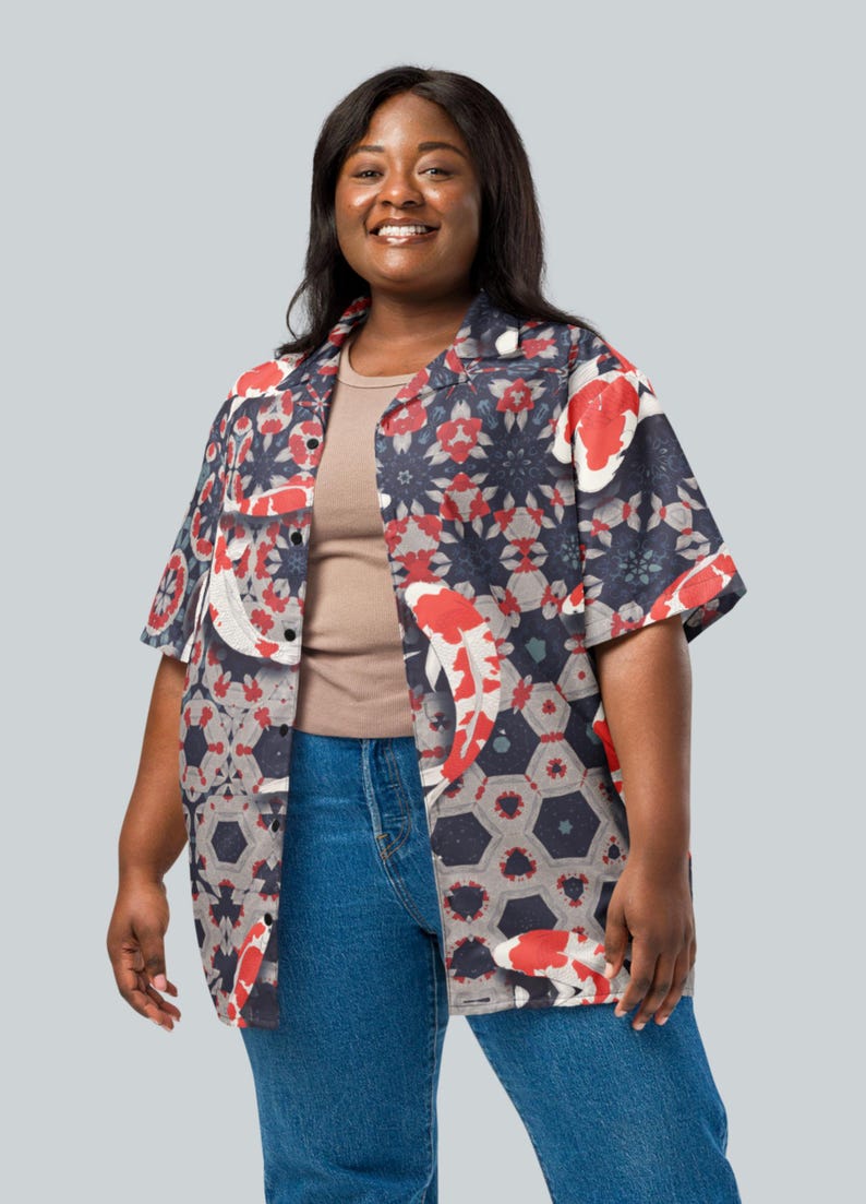 May include: Short-sleeved shirt featuring a koi fish and geometric design in red, white, and navy blue. The shirt is worn with a neutral-toned undershirt and blue jeans. The shirt has a relaxed fit.
