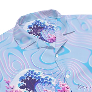 May include: A blue and pink patterned shirt with a large wave and cherry blossom design. The collar has a label that reads "Sakura Wave by KaciX".