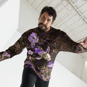 Puede incluir: Una camisa de manga larga con fondo oscuro y un dise&ntilde;o de pez koi morado y blanco.