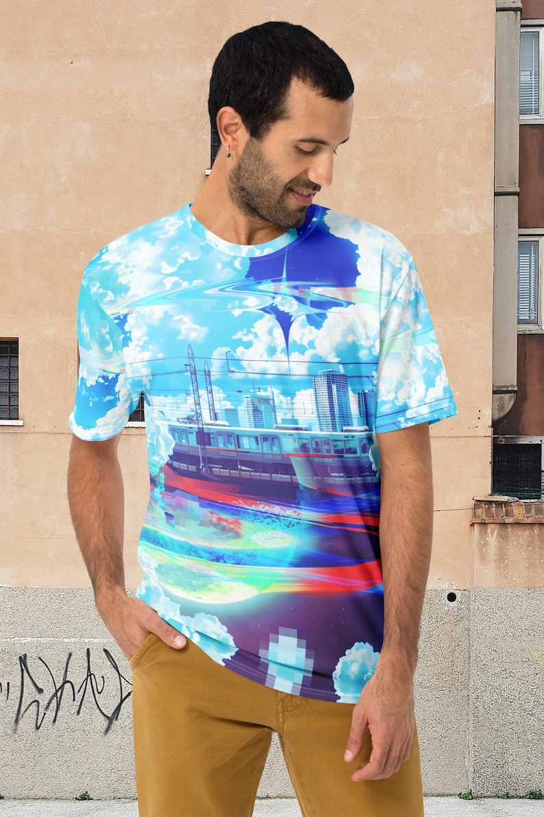 Op de afbeelding: Een blauw, wit en paars T-shirt met een grafische print van een stadsbeeld en een trein. De trein is omringd door wolken en een blauwe lucht.