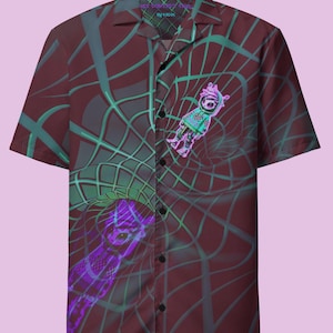 May include: A maroon short-sleeved button-up shirt with a green and purple geometric pattern. The shirt features a graphic of a cartoon character with a purple and green color scheme.