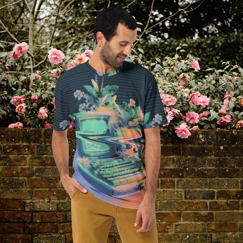 Puede incluir: Una camiseta azul oscuro y verde con un gr&aacute;fico de computadora retro. La computadora est&aacute; rodeada de flores y tiene una pantalla verde. La camiseta tiene un patr&oacute;n a rayas.