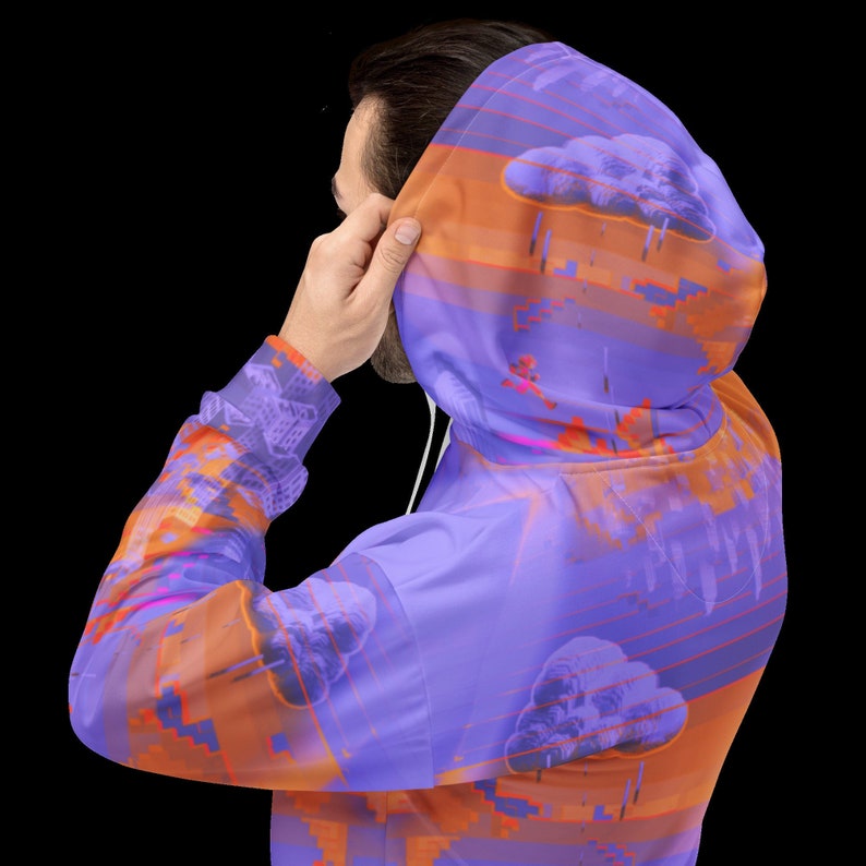 May include: A hooded sweatshirt with a vibrant, abstract design. The hoodie features a purple base color with orange and pink accents, creating a layered effect. The design includes cloud and cityscape motifs. The hoodie has a drawstring and a front pocket.