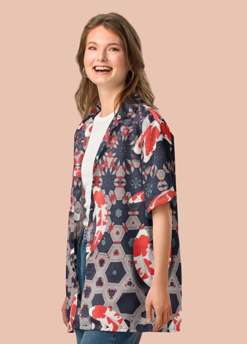May include: A short-sleeved shirt with a koi carp design. The shirt has a navy blue background with red and white koi carp and geometric shapes. It is worn over a white t-shirt and blue jeans.