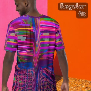 May include: A purple, pink, blue, and green abstract graphic print t-shirt with a regular fit. The t-shirt is being worn by a person standing in front of a pink and orange wall.
