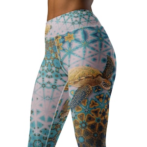 Könnte beinhalten: Hoch taillierte Leggings mit einem lebendigen, komplizierten Muster in Türkis, Hellblau und Gold. Eine detaillierte Illustration einer Meeresschildkröte ist prominent auf der Seite zu sehen. Die Leggings bestehen aus einem dehnbaren Material.