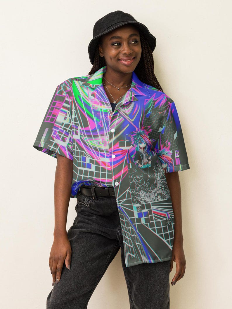 May include: A person wearing a black bucket hat and a short-sleeved button-up shirt with a colorful abstract print. The shirt has a black and white grid pattern with pink, blue, and green accents.