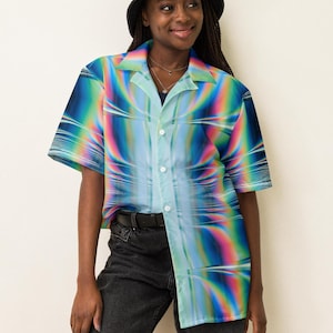 May include: A person wearing a blue, green, and rainbow patterned short-sleeved button-up shirt with a black bucket hat and black jeans.