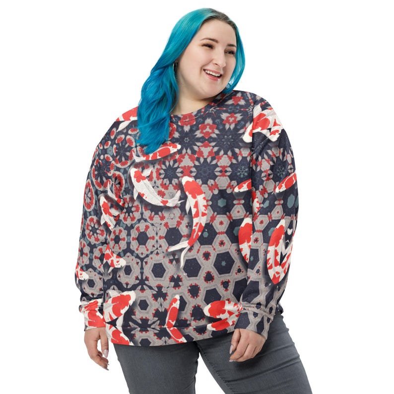 May include: A crew neck sweatshirt featuring a repeating pattern of koi fish in red, white, and black against a dark blue background. The design incorporates geometric shapes and floral elements. The sweatshirt has long sleeves and a relaxed fit.